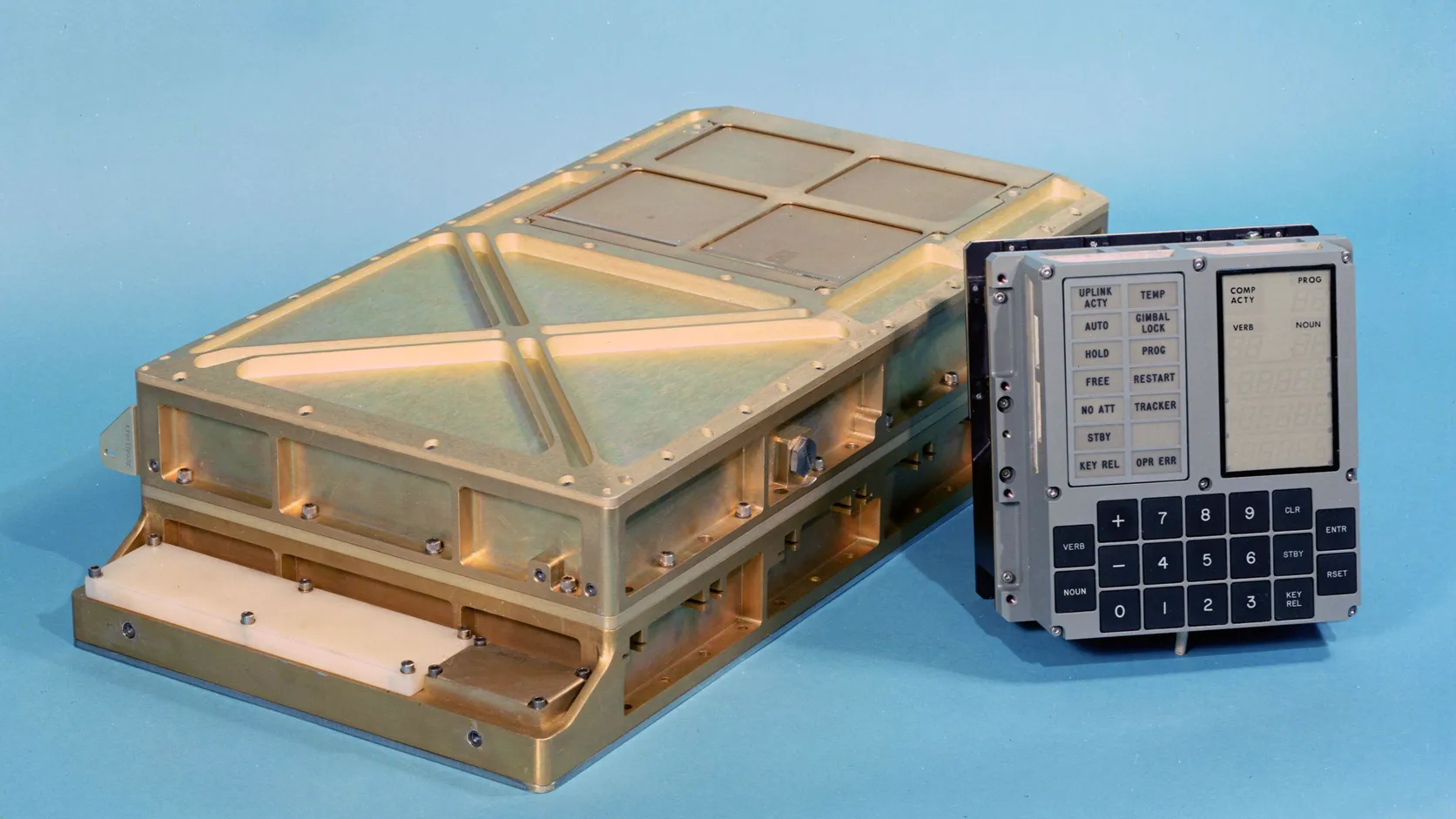 The Apollo Guidance Computer, a gold-colored metal box, beside its DSKY display and keyboard with VERB, NOUN and number keys